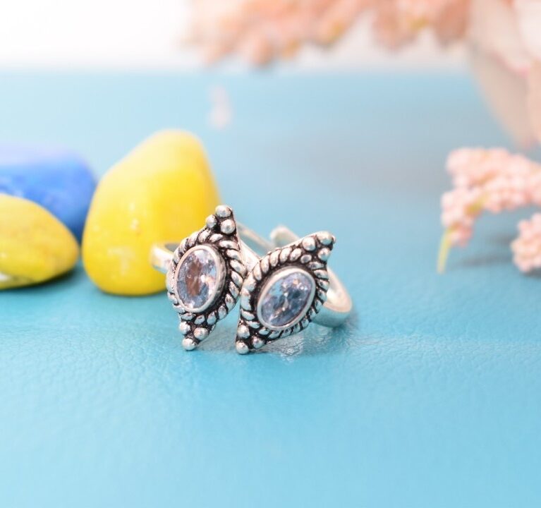 A pair of silver toe rings with white cutstones set in a marquise shape.