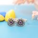 A pair of silver toe rings with purple stones set in a heart-shaped design.