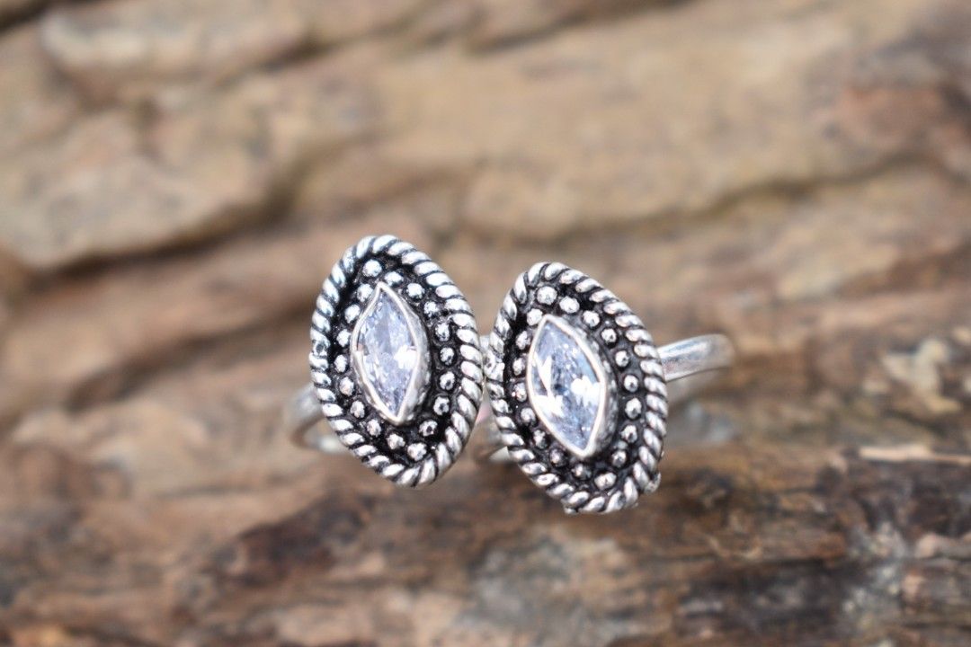 A pair of silver toe rings with white cutstones set in a marquise shape.