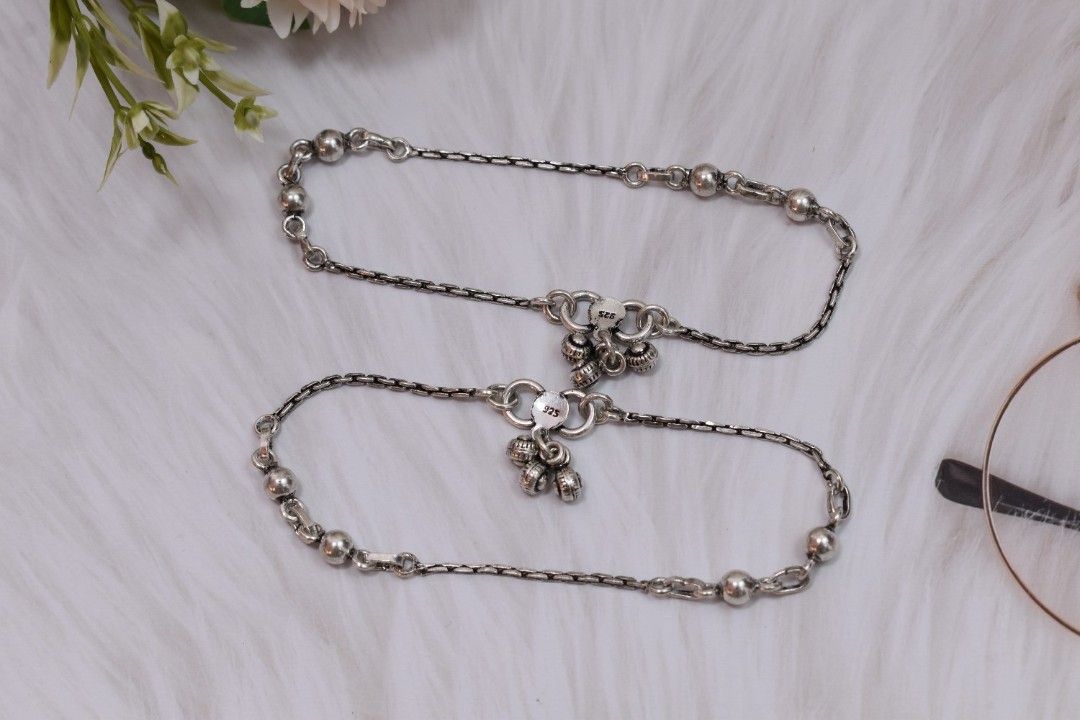 A silver chain with alternating links and spherical beads.