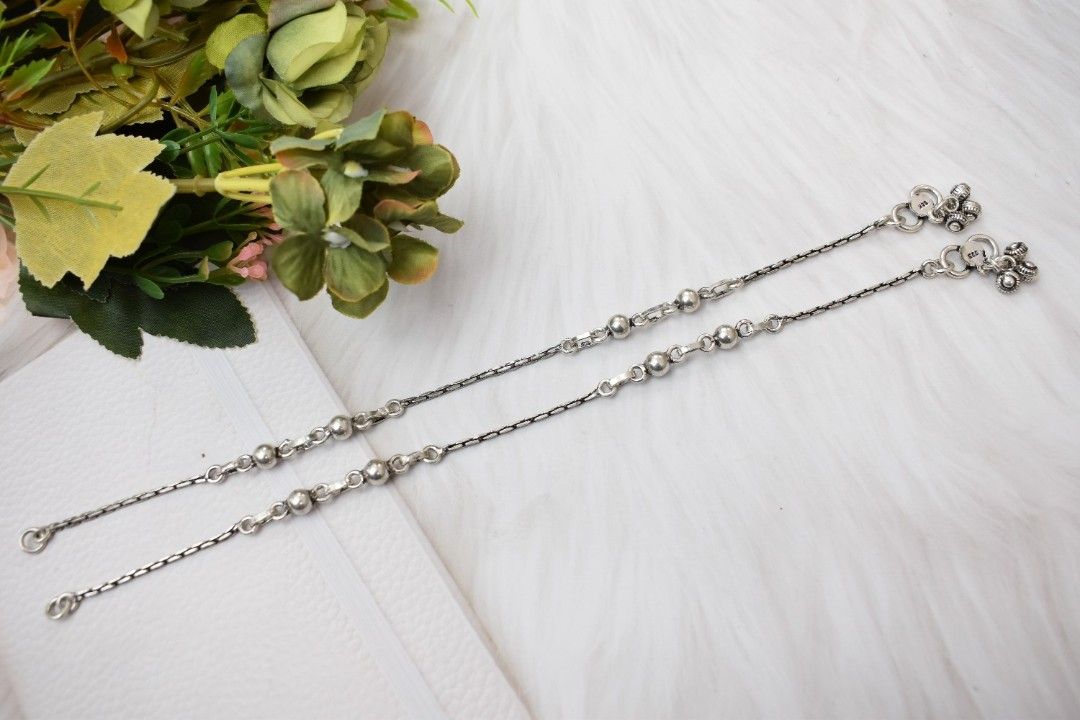 A silver chain with alternating links and spherical beads.
