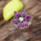 A silver ring with a flower-shaped design featuring pink cutstones and a white center cutstone.