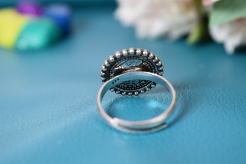 A vintage silver ring featuring a Queen Victoria coin set in a circular design with beaded edges.
