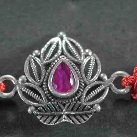 A 925 sterling silver Rakhi featuring an intricate design with a central red stone for Raksha Bandhan.