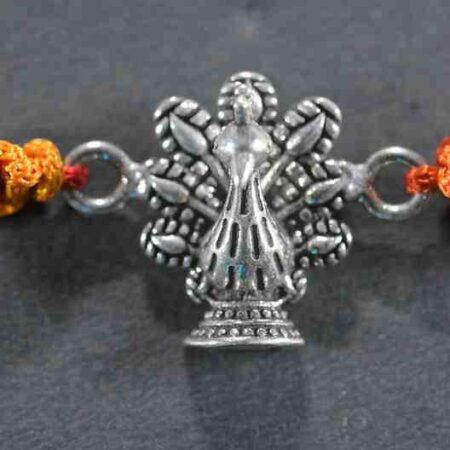 A silver Rakhi featuring a classic dancing peacock design.