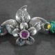 A delicate silver Rakhi with a fusion of leaf and floral designs