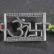 A silver Rakhi featuring divine symbols of Om and Swastik
