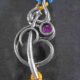 A silver Rakhi featuring a divine Om symbol intertwined with a Trishul (trident).