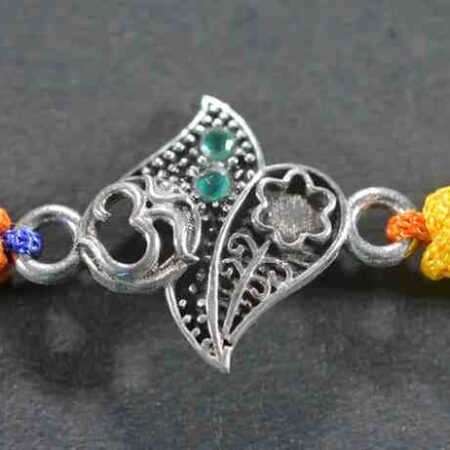 A silver Rakhi featuring an intricate design of the Om symbol