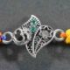 A silver Rakhi featuring an intricate design of the Om symbol