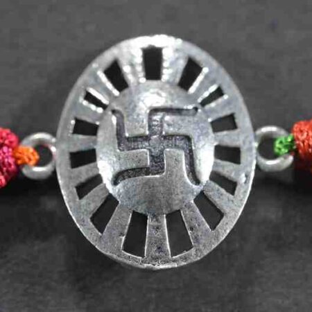 A silver Rakhi featuring an oval shape with a divine Swastik design.