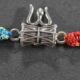 A silver Rakhi featuring intricate designs of Lord Shiva's Damru and Trishul