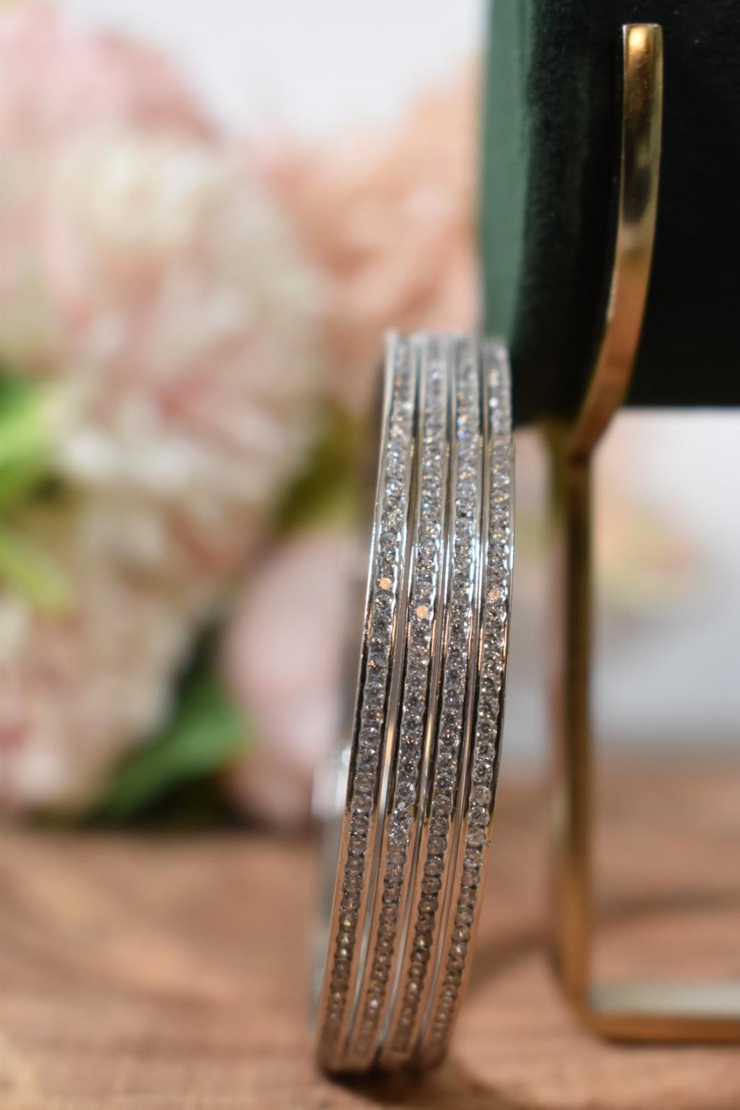A set of silver bangles adorned with rows of sparkling CZs.